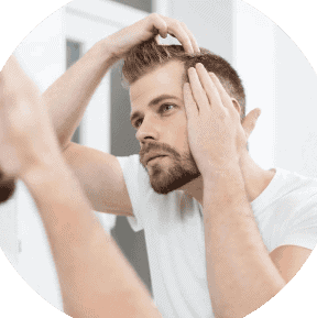 man standing in a mirror examining his hairline 768x768.jpg.webp